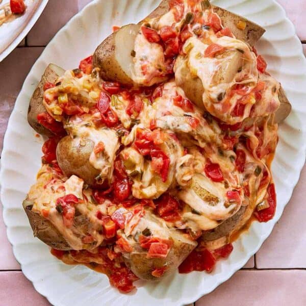 Cheesy Potatoes, also known as Papas Chorreadas on a white serving plate.