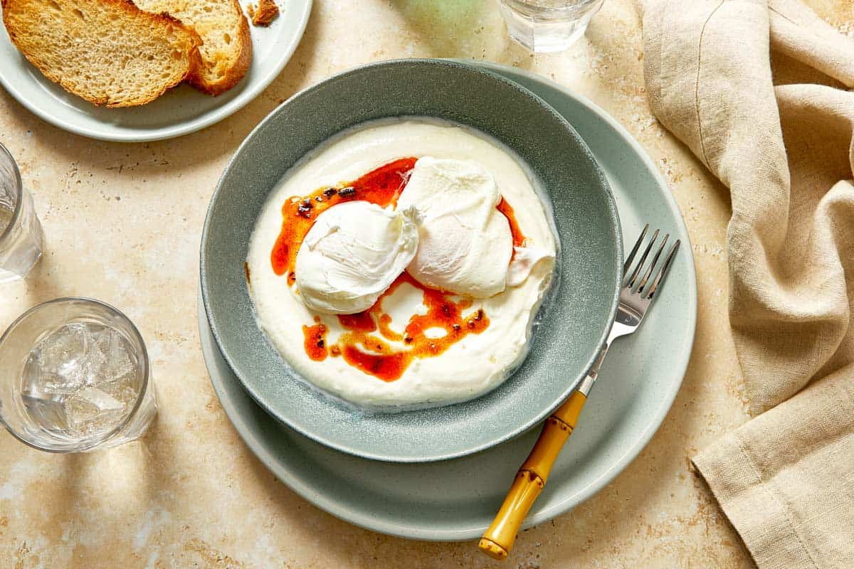 Poached eggs placed over yogurt and chili butter.