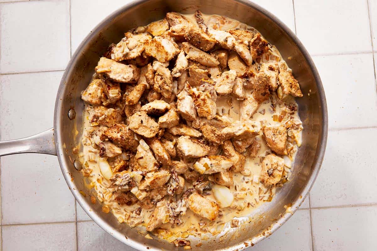 Sautéed chicken in a stainless steel skillet.