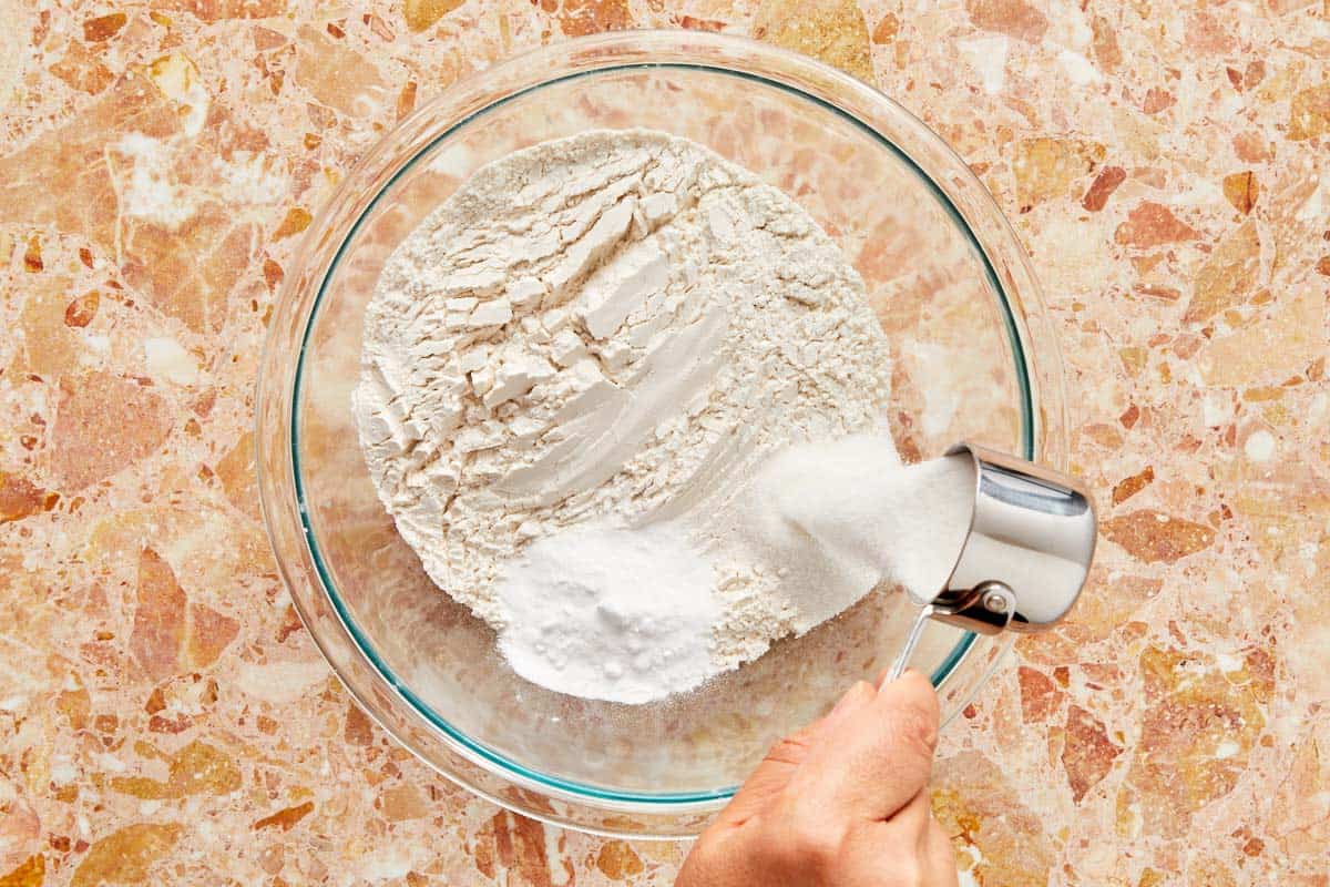 Mixing flour in a bowl, preparing dry ingredients for a recipe.