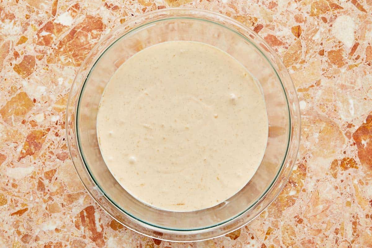 A bowl of thick batter resting on a marble counter.