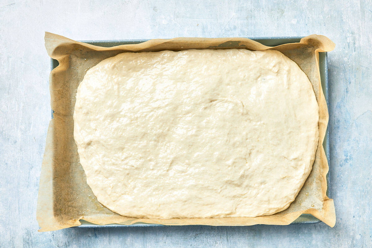 Dough spread fully in the baking pan, ready to rest.