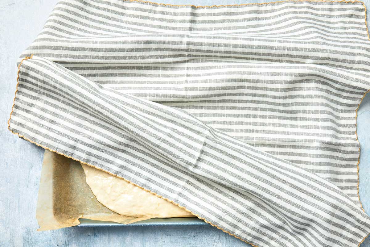 Baking pan covered with a striped cloth for the first rise.