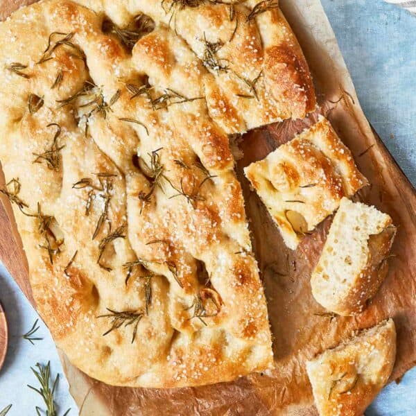 Sliced focaccia showing airy texture, crispy edges, and rosemary on top.