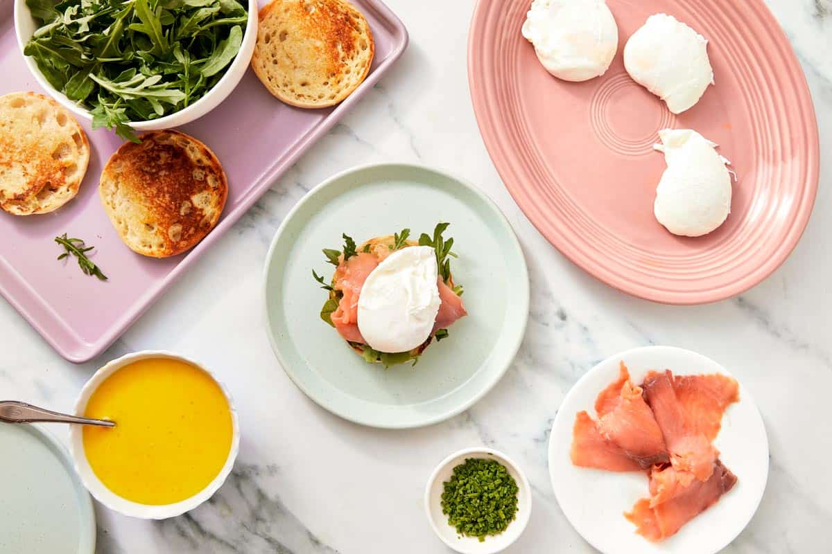 A poached egg placed on top of a prosciutto-covered muffin, surrounded by the other ingredients.