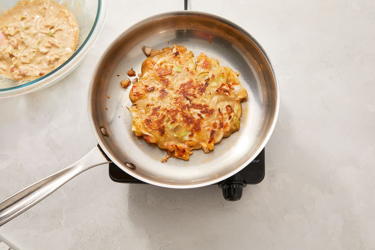 Thick batter poured into the pan over the cooked shrimp, shaped into a circle.