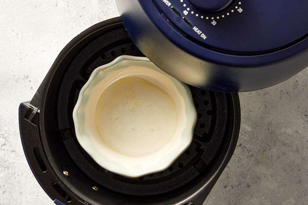 Cup in the air fryer being preheated with water.