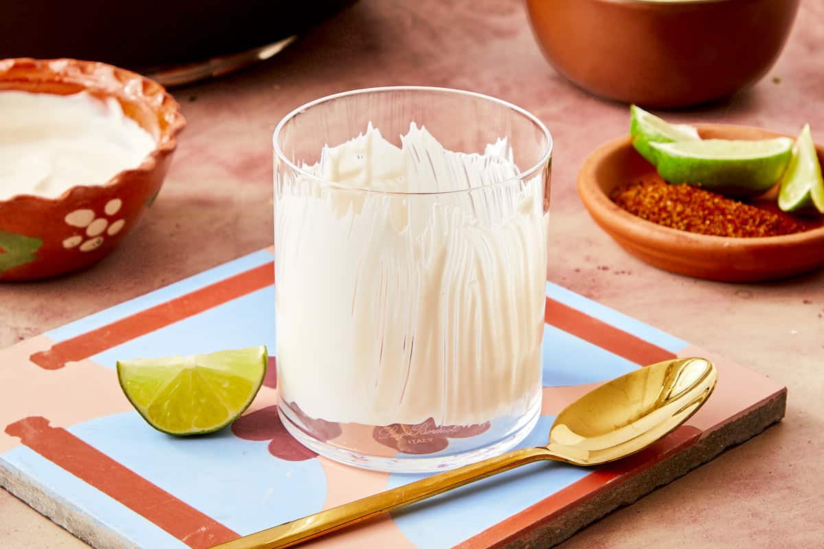 Creamy yogurt, presented in a cup with a layer of crema and grated cheese.