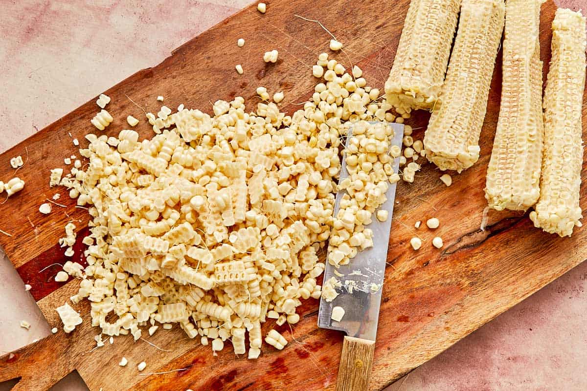 Fresh corn on the cob with a sharp knife