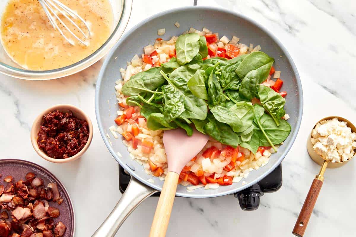 Fresh spinach and crumbled feta layered over cooked vegetables.