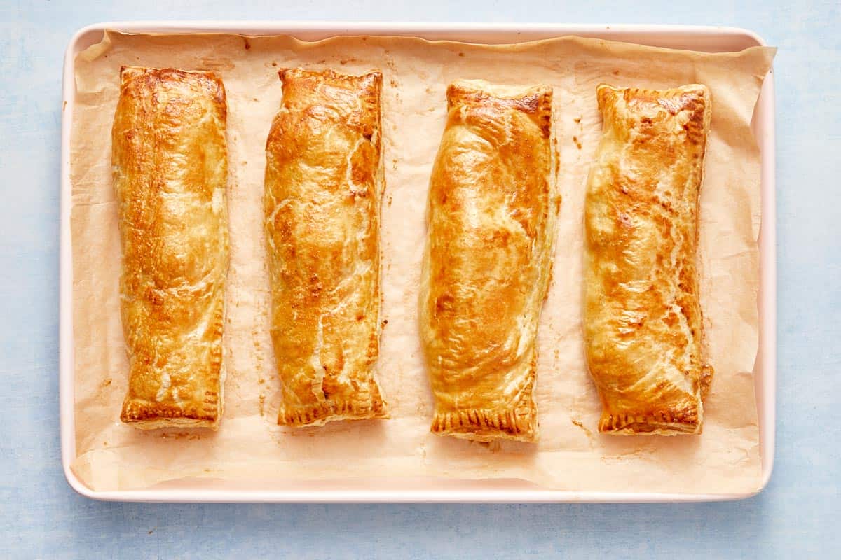 Freshly baked golden salmon parcels on a tray, straight from the oven.