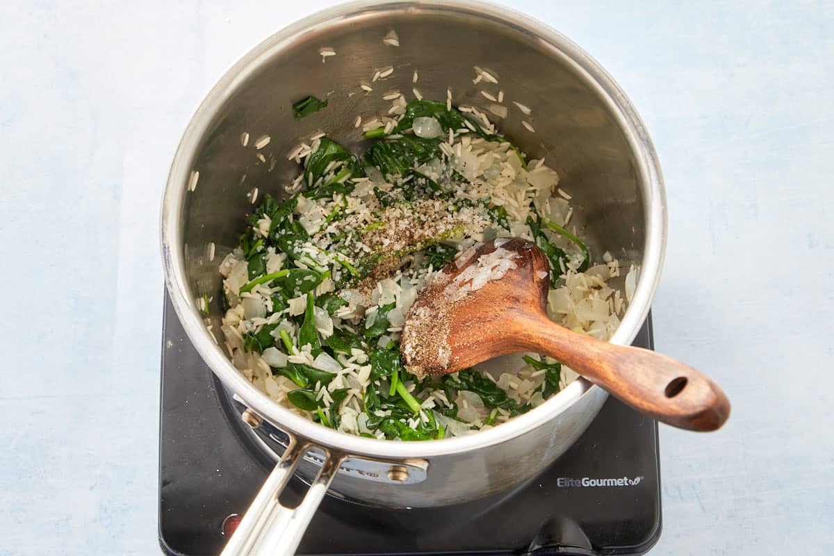 Mixing parsley and lemon juice into the cooked spinach and rice mixture.