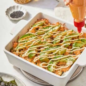 A serving of Sushi Bake garnished with creamy avocado, highlighting the dish's vibrant and inviting appearance.