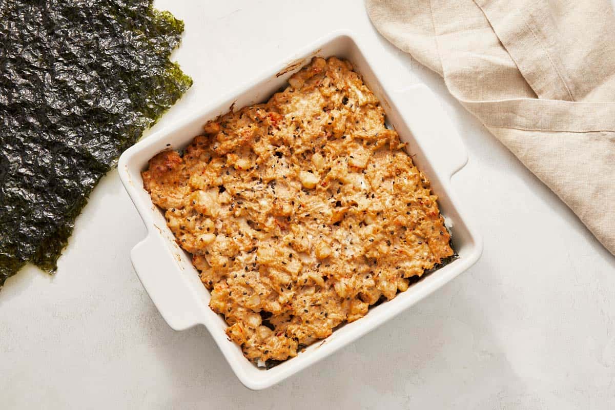 A baked sushi casserole showcasing rice and seaweed in a ceramic dish