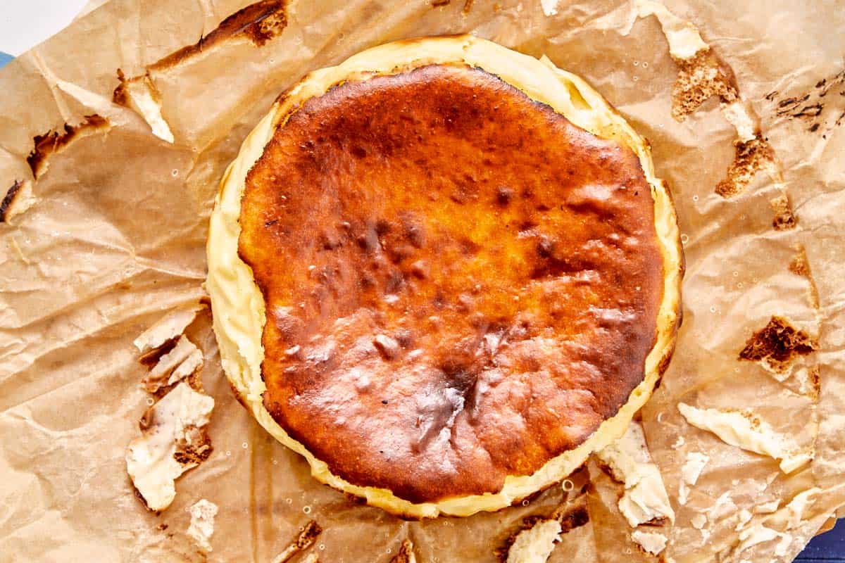 Basque cheesecake with caramelized top resting on parchment paper