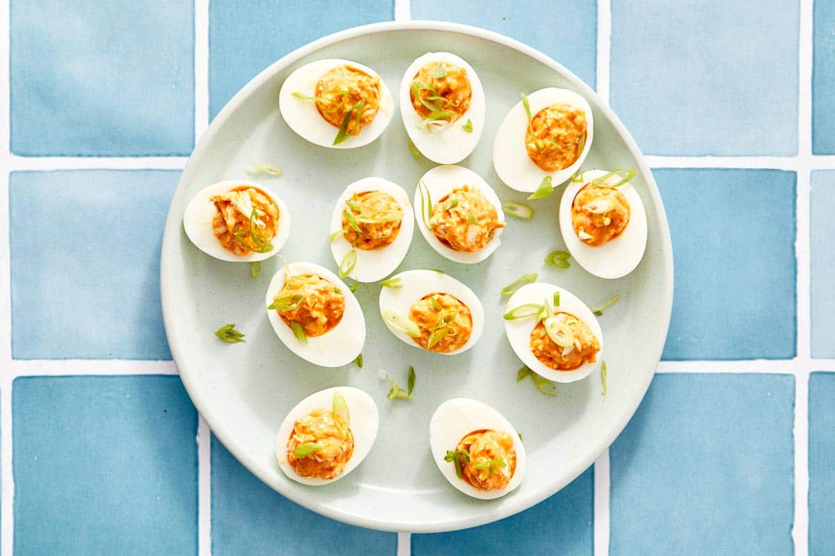 Overhead of buffalo chicken deviled eggs with green onion.