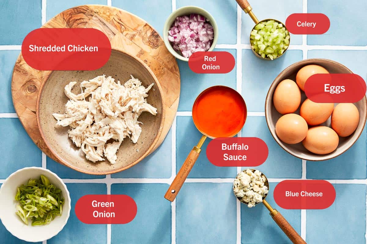 Ingredients for buffalo chicken deviled eggs on blue tile.