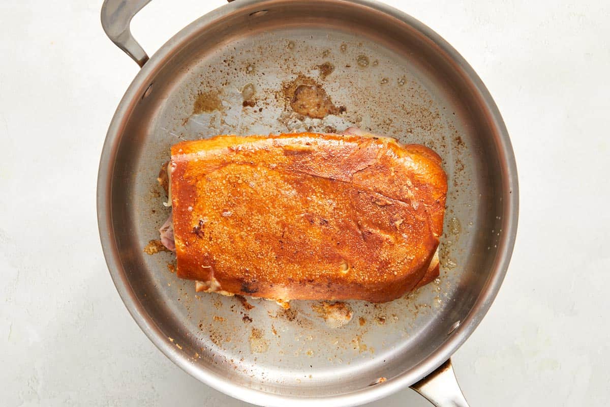 Cuban sandwich toasting in a skillet.