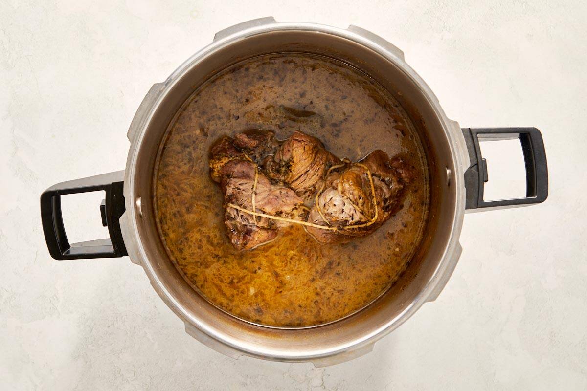 Cooked pork in broth inside a pot.