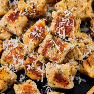 Close-up of golden gnocchi pieces with parmesan shavings.