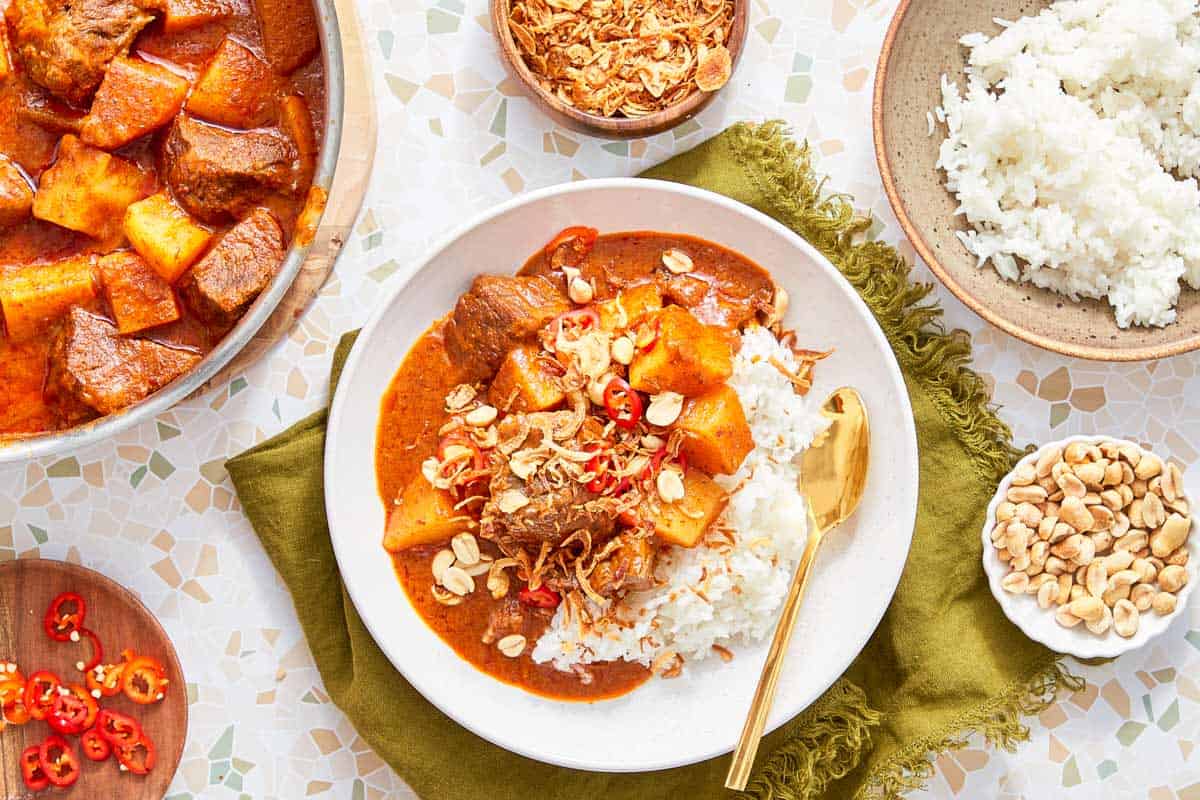 Massaman Beef Curry served with jasmine rice, peanuts, and crispy shallots.