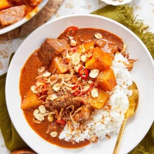 Massaman Beef Curry served over jasmine rice, topped with peanuts and crispy shallots.