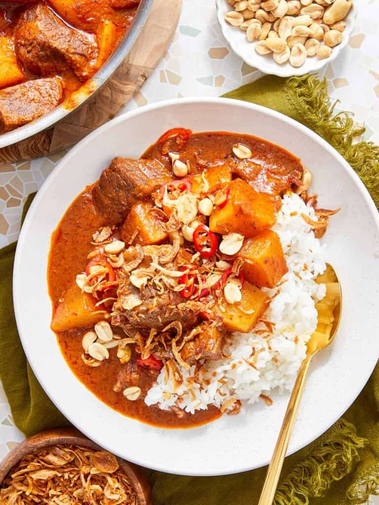 Massaman Beef Curry served over jasmine rice, topped with peanuts and crispy shallots.