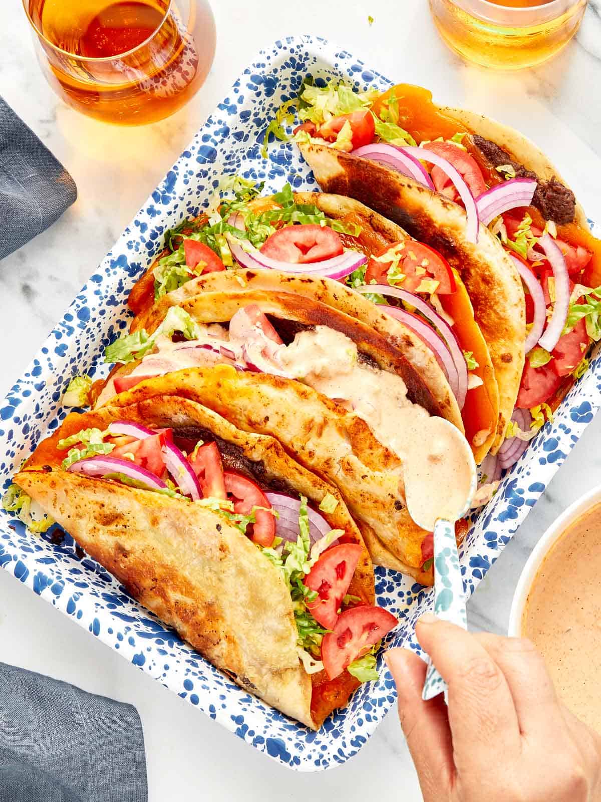 Smash burger tacos in a blue speckled tray.