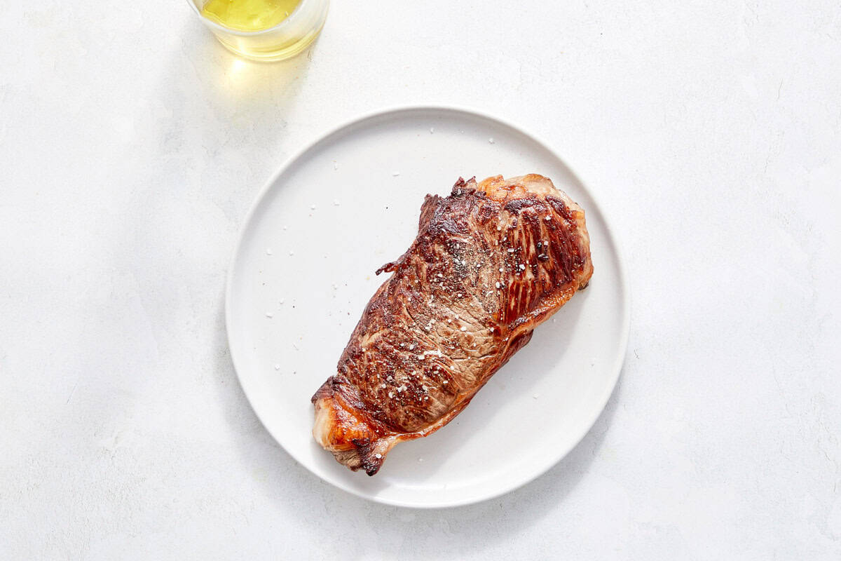 Seared steak resting on a plate.