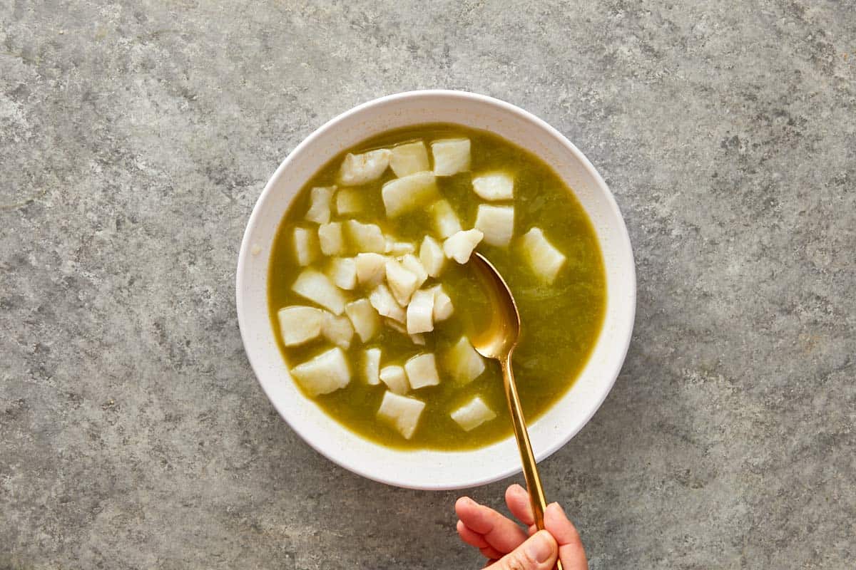 Fresh diced white fish being stirred into the cold marinade.