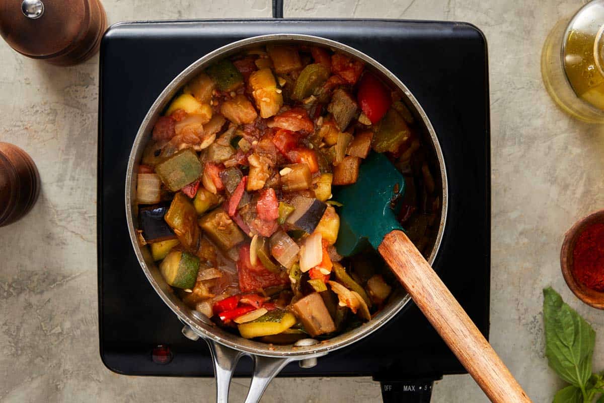 Cooked ratatouille being stirred in a pot.