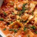 close up of ravioli in a creamy tomato beef sauce