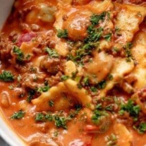 close up of ravioli in a creamy tomato beef sauce