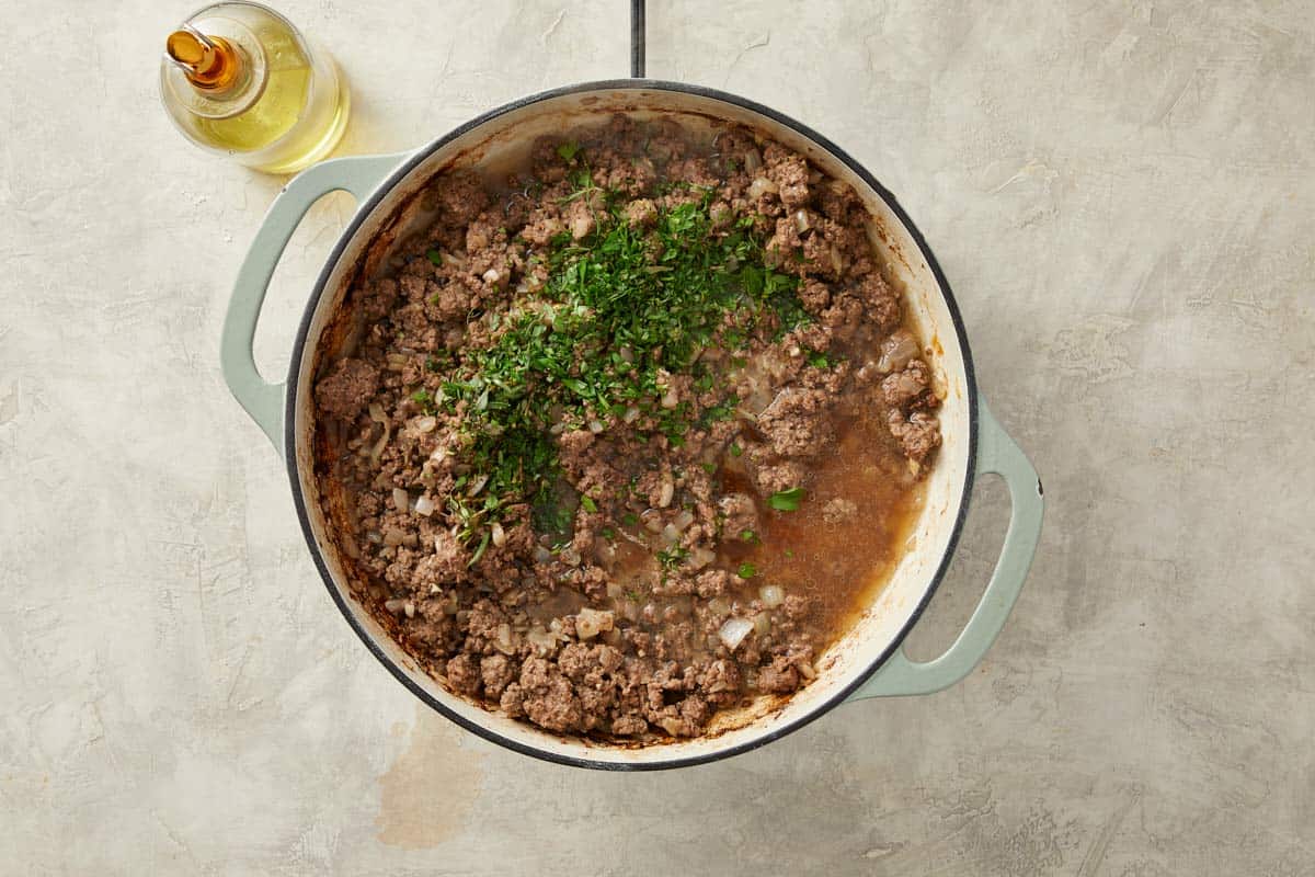 Meat sauce simmering with herbs, tomato paste and stock.