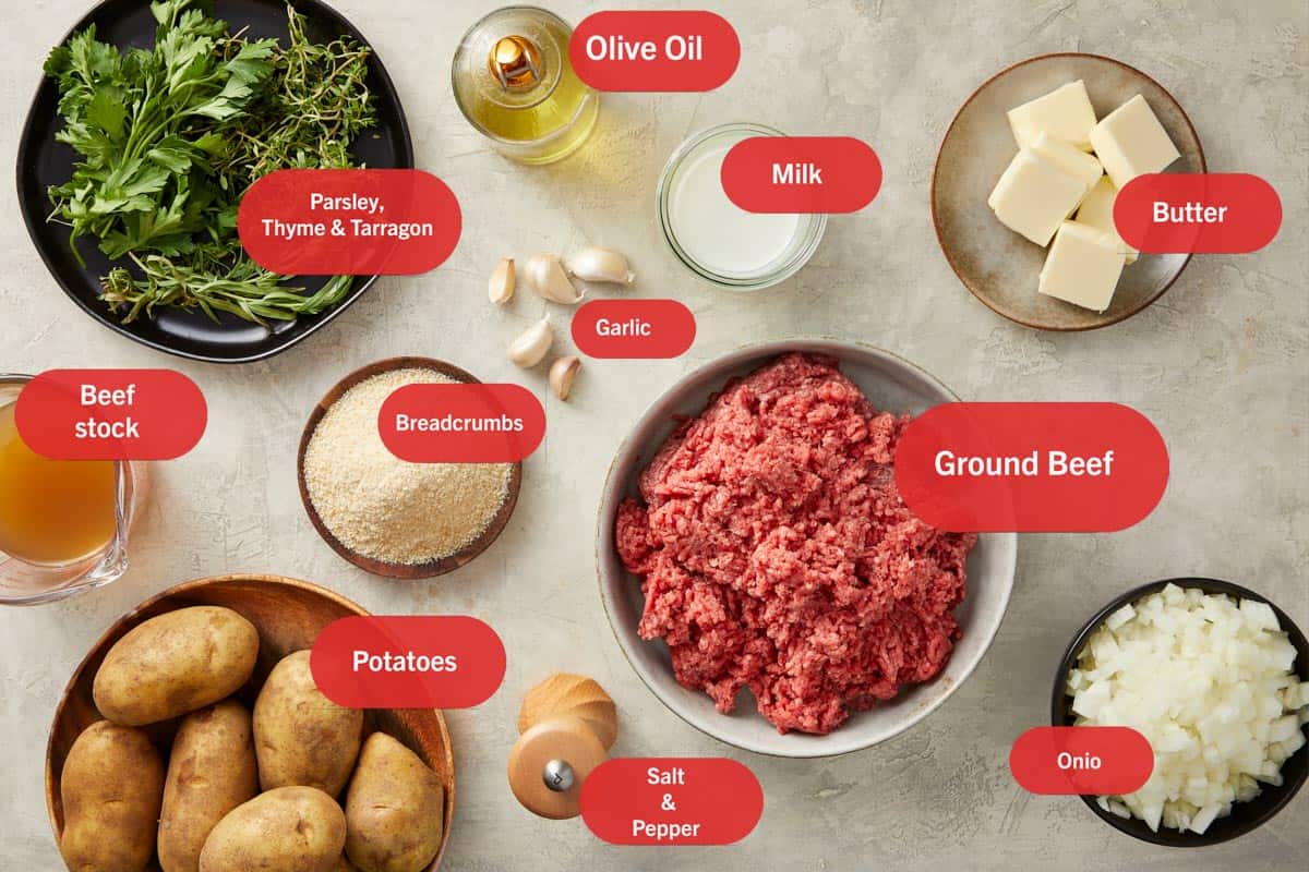 Ingredients for Shepherd’s Pie arranged: potatoes, ground meat, onions, carrots, peas, stock, butter and milk.