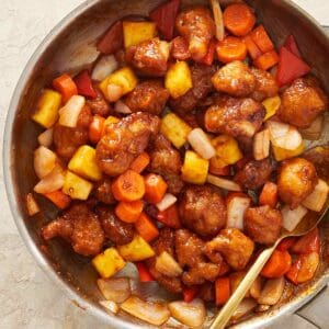 Homemade sweet and sour chicken with crispy bites of chicken, fresh vegetables, pineapple, and a glossy tangy sauce.
