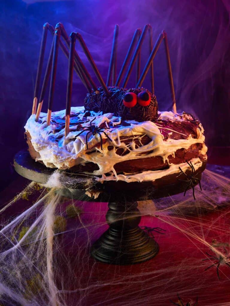 Halloween Spider Cake on display, surrounded by cobwebs and spooky lighting.