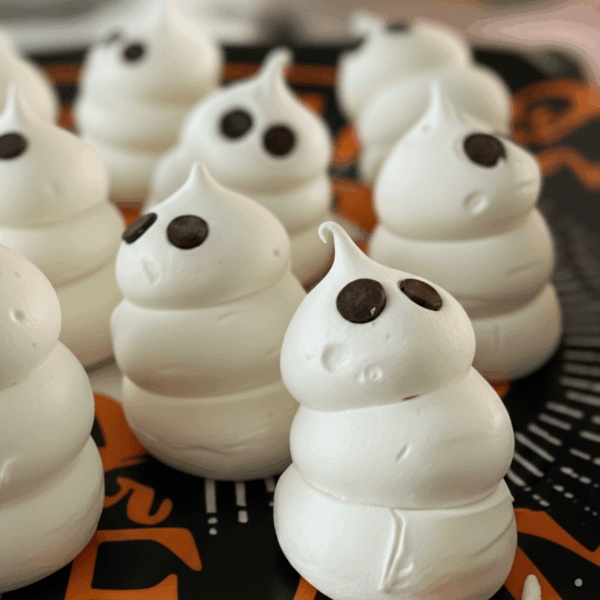 Swiss Meringue Ghosts sitting on a trick or treat plate