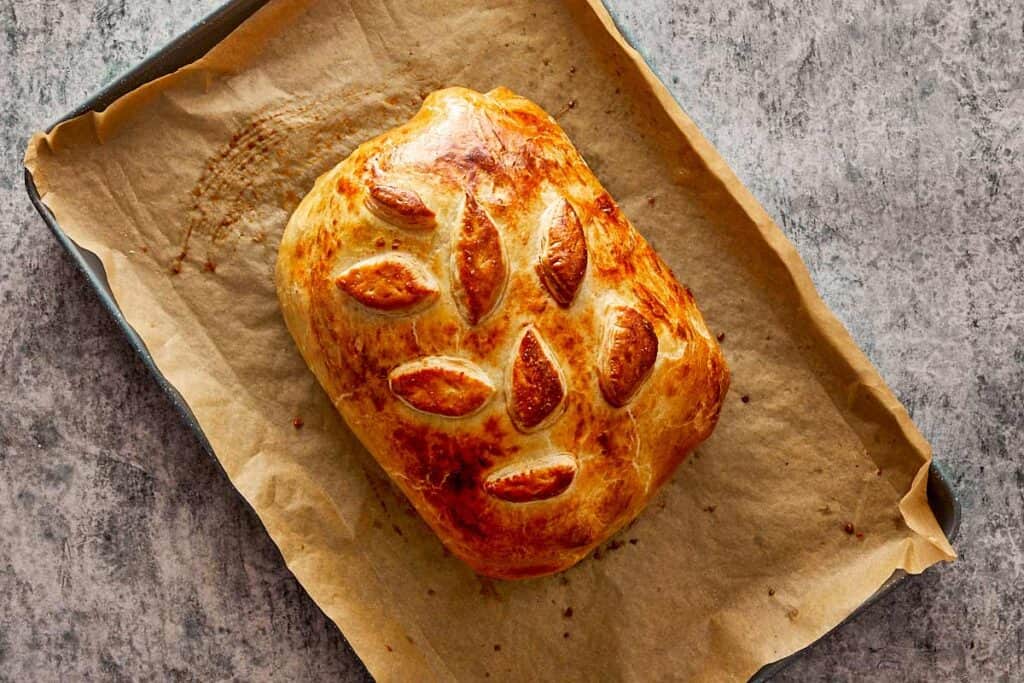 cooked beef Wellington resting on a pan