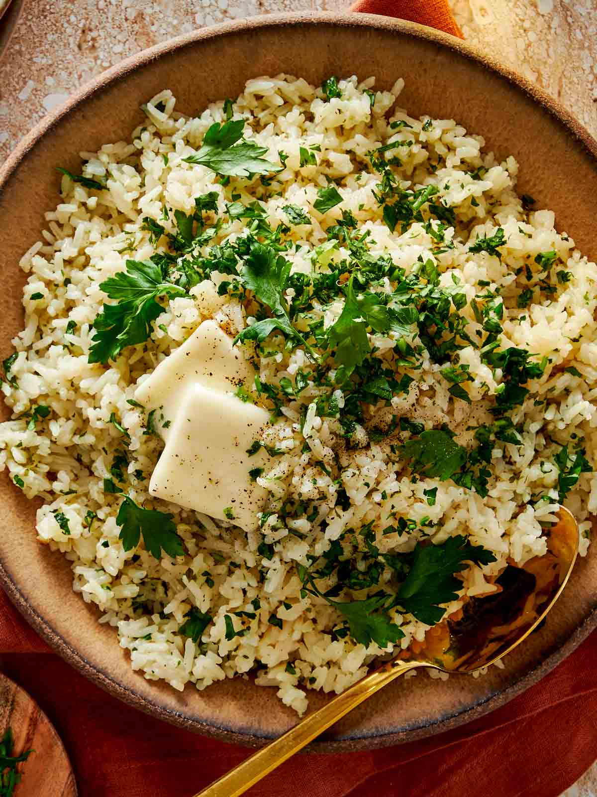 close up top down shot of garlic butter rice in a bowl with melting butter