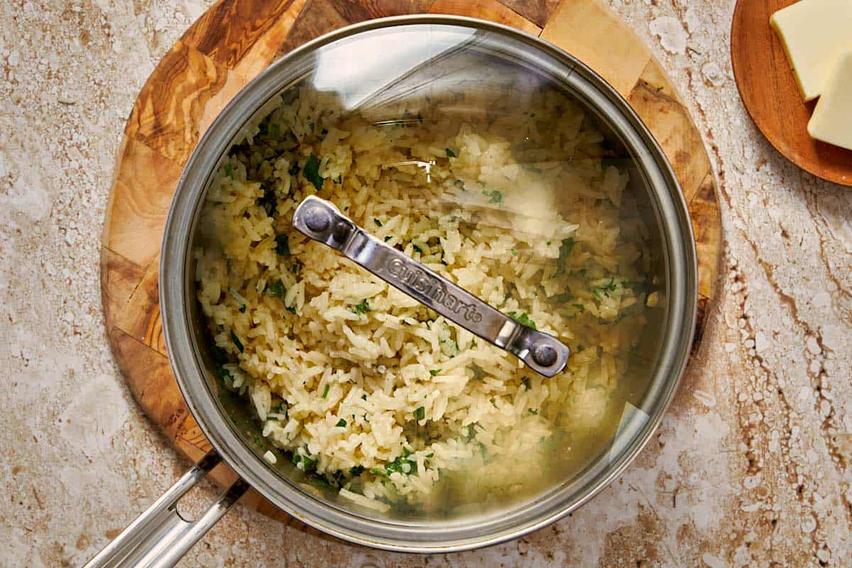 rice being cooked in a pot with a lid