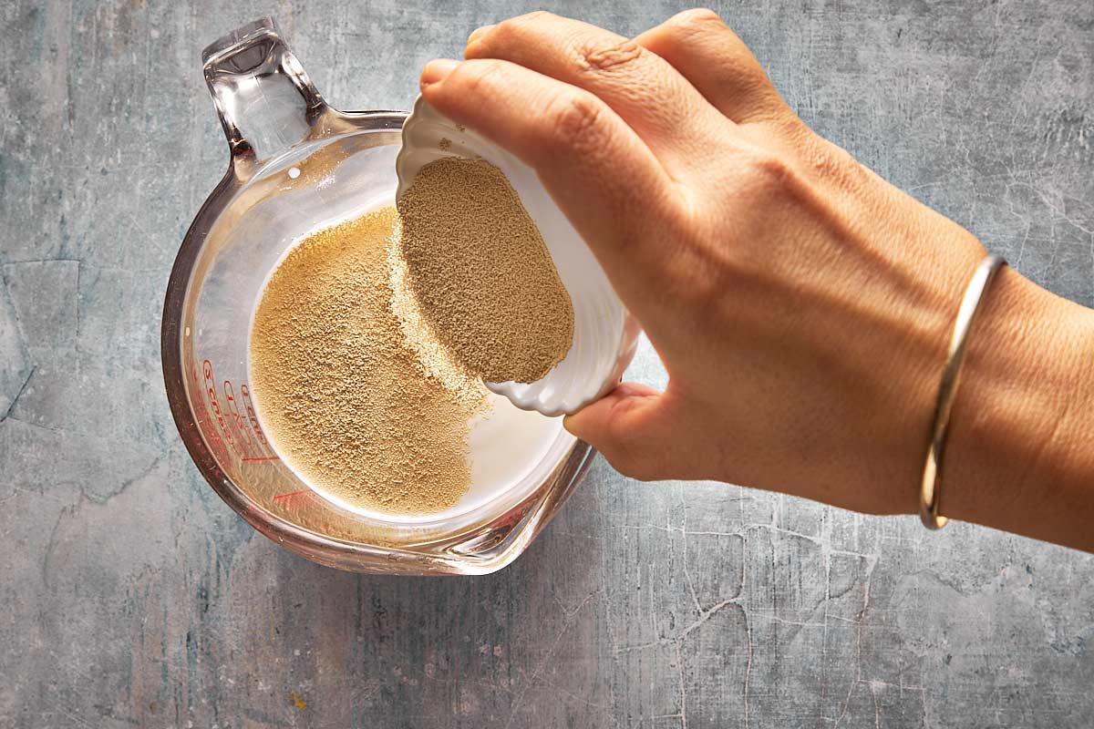 top down shot of a pitcher with water, milk sugar and dry yeast being poured in
