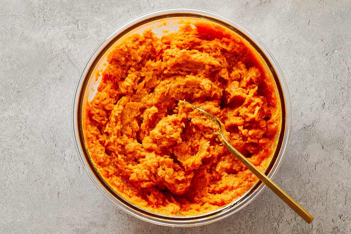 Brown bowl filled with pecan streusel mixture made from brown sugar, butter, and chopped pecans.