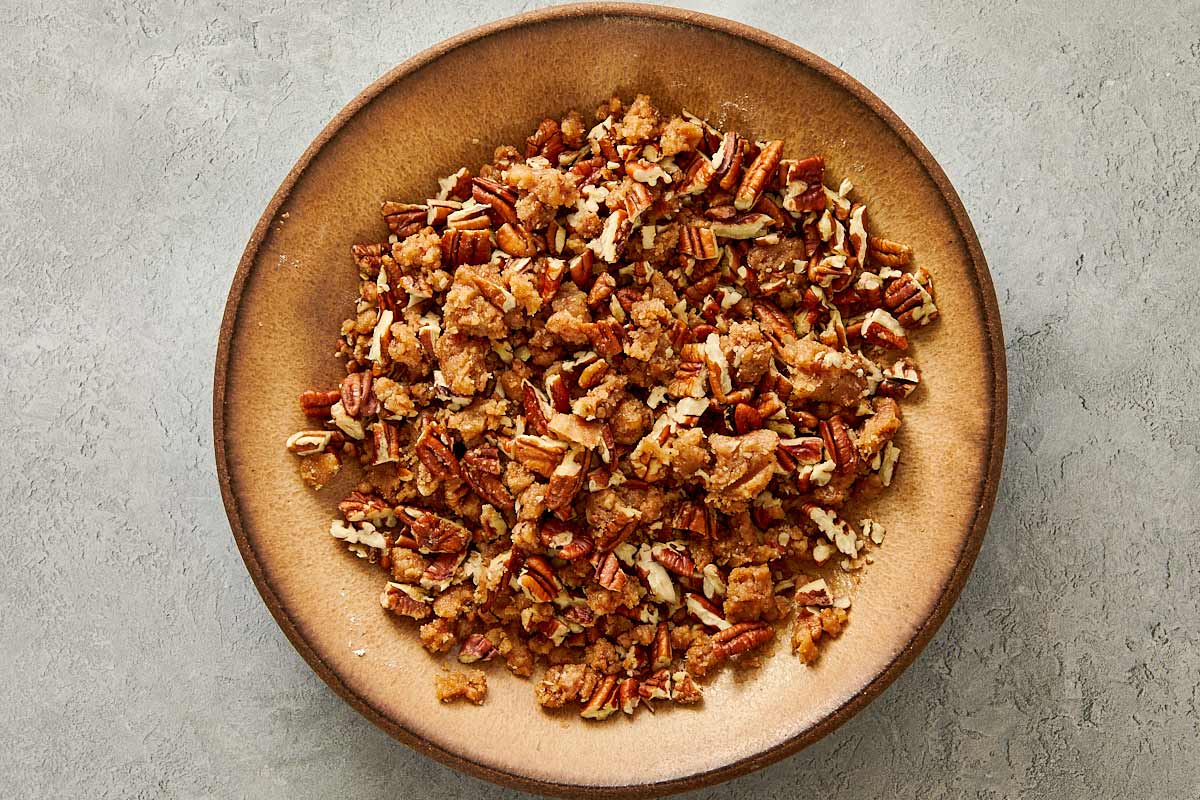 Baking dish filled with sweet potato casserole topped with a chunky brown sugar pecan streusel before adding marshmallows