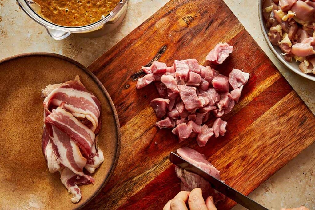 chopping up meat on a chopping board with a knife