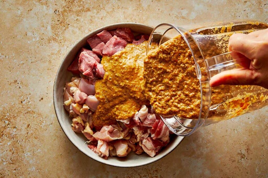 raw meat in a pot pouring over with some spices