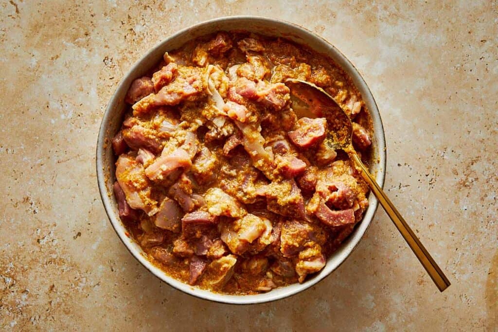 chopped up chicken and pork in a stew in a pot fully cooked