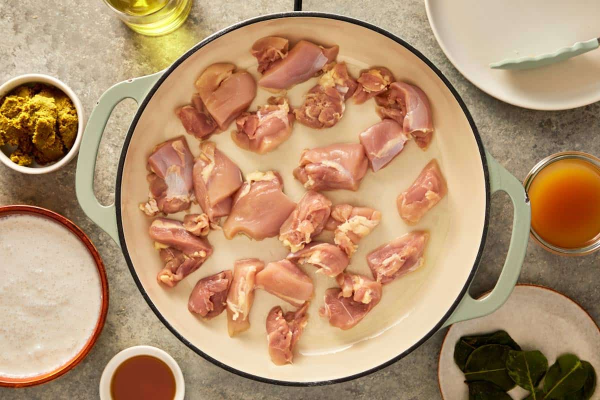 top down shot of a pan with chicken thigh being cooked