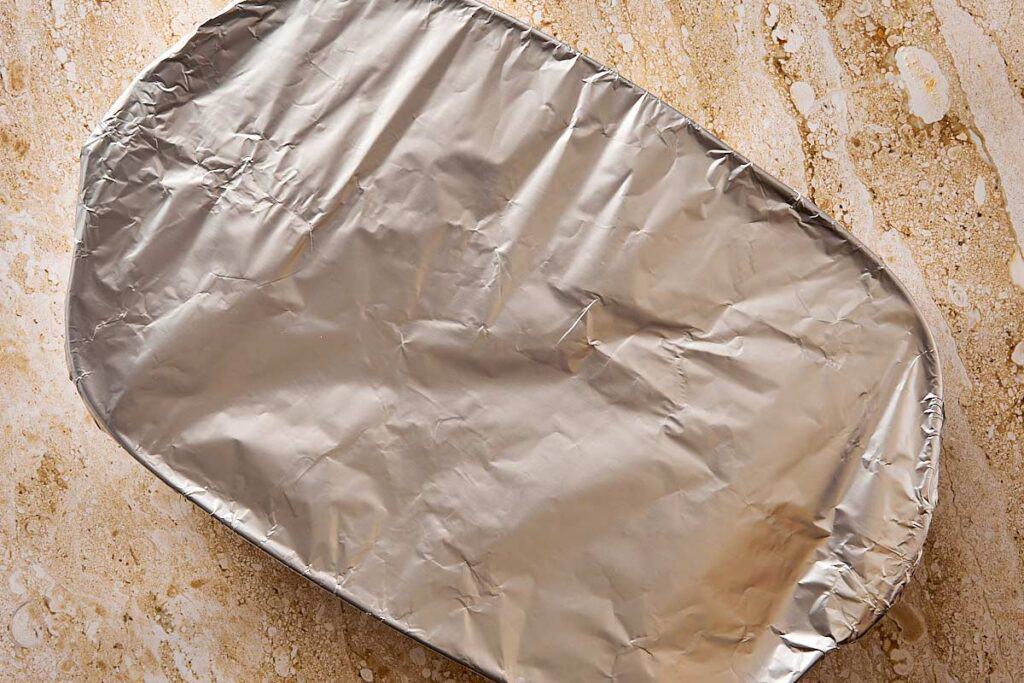 a top down shot of a baking dish covered with aluminum foil