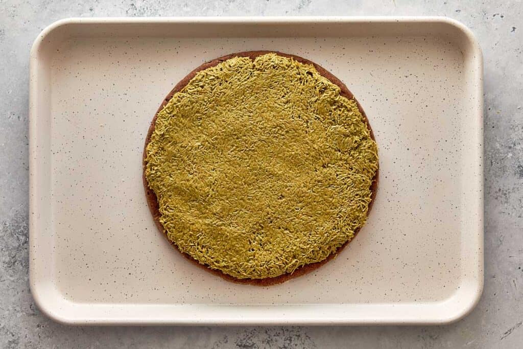 assembling the cake with a frozen pistachio disk on top
